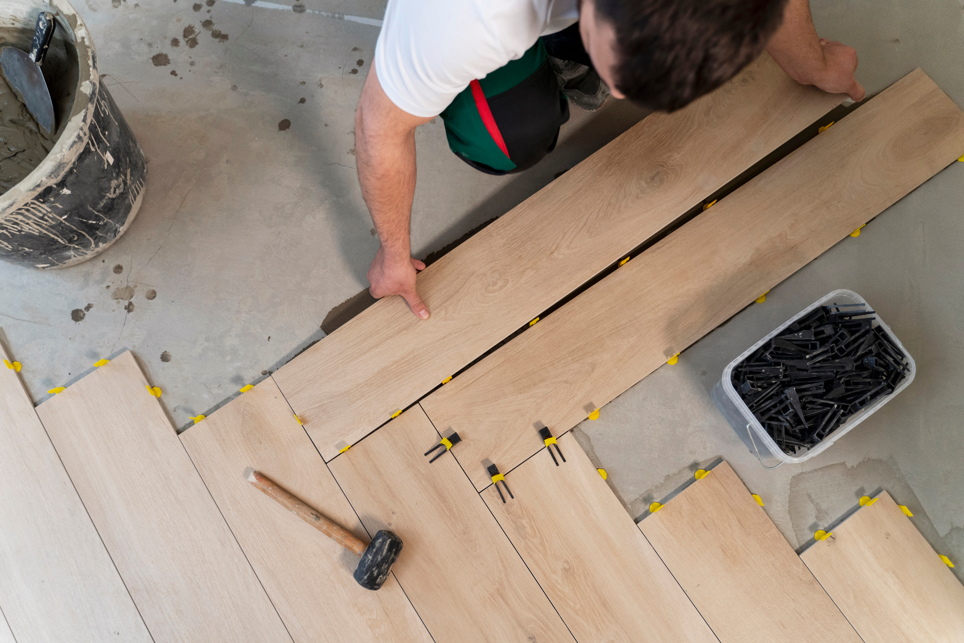 Professional flooring installer laying planks