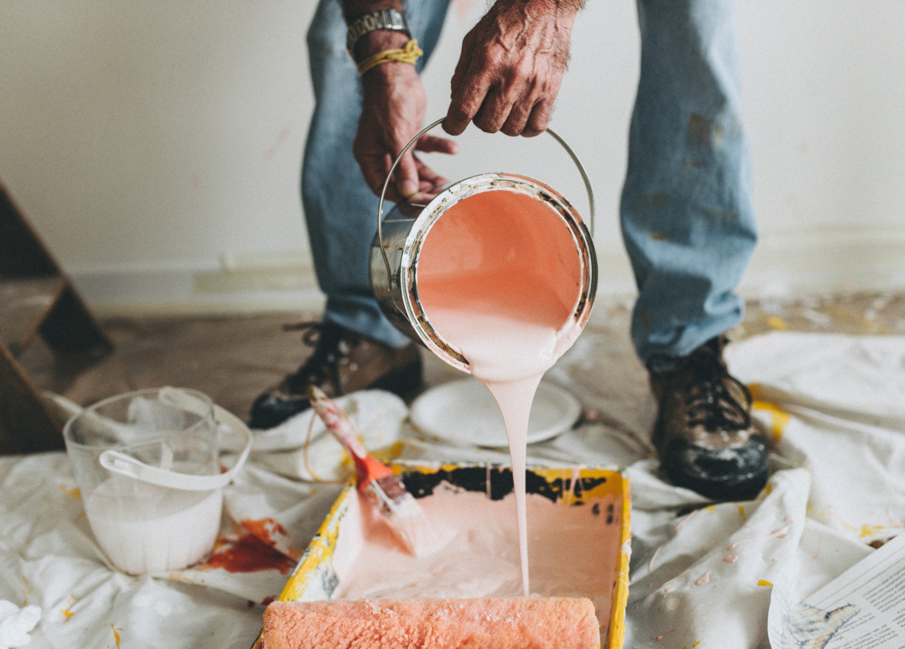 Painter pouring paint into tray