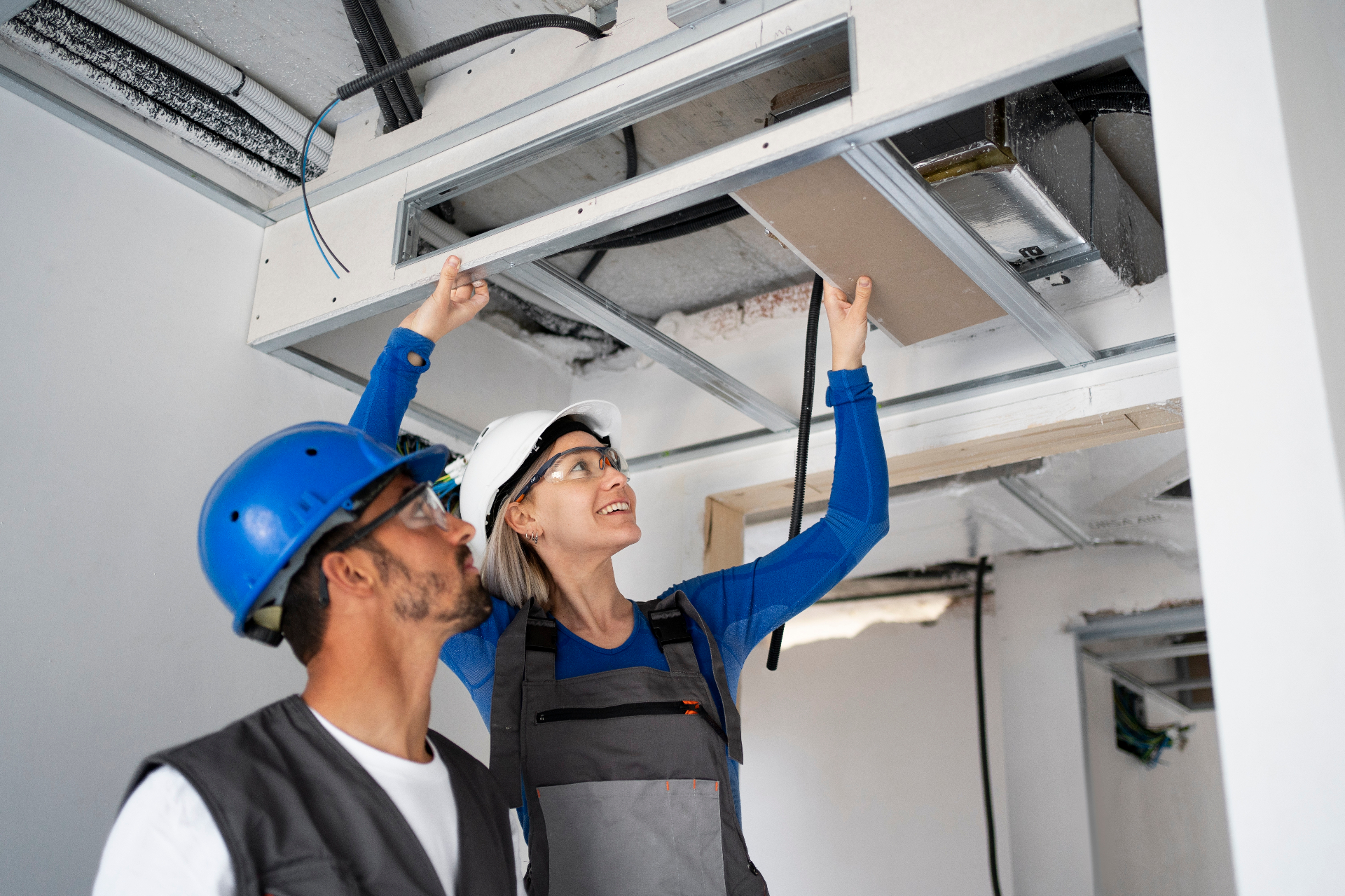 HVAC technicians inspecting ceiling installation
