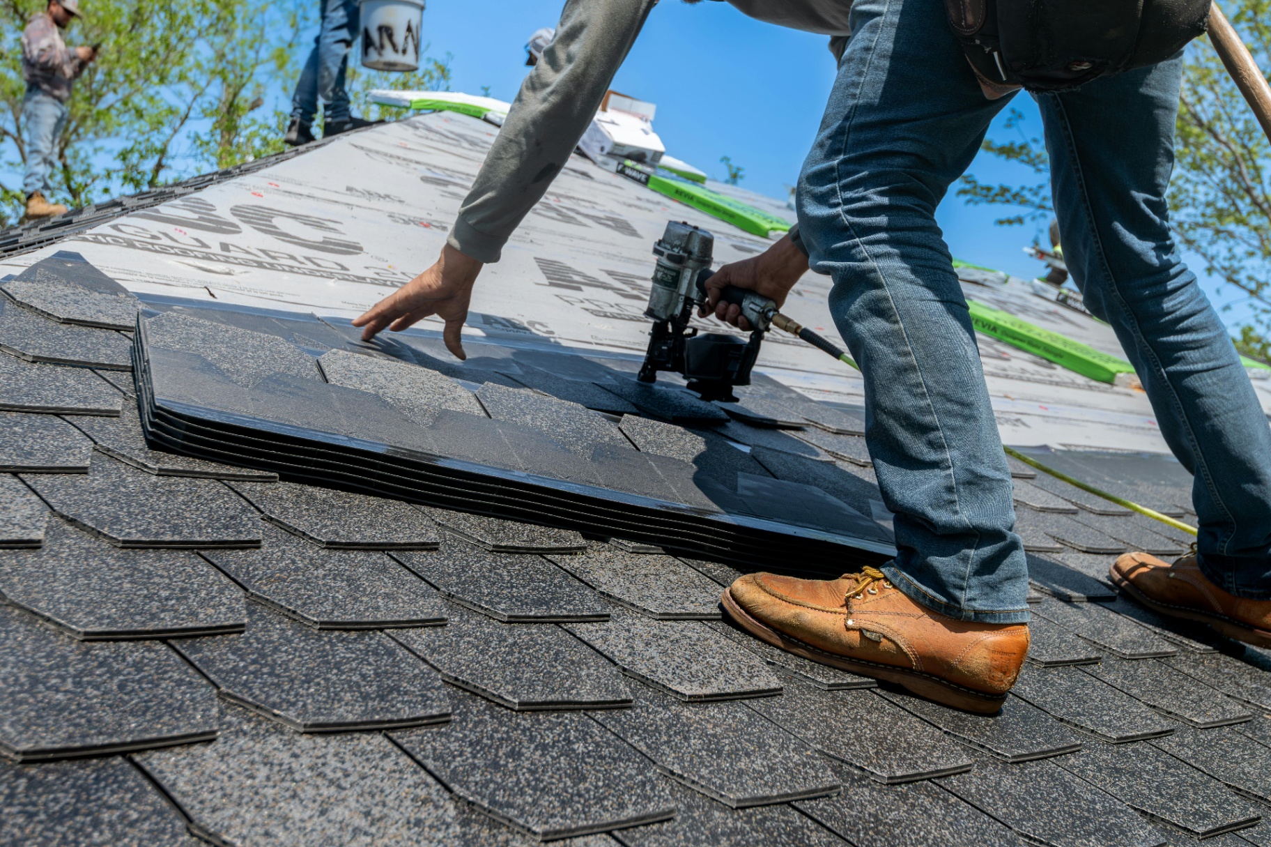 Professional roofer installing shingles
